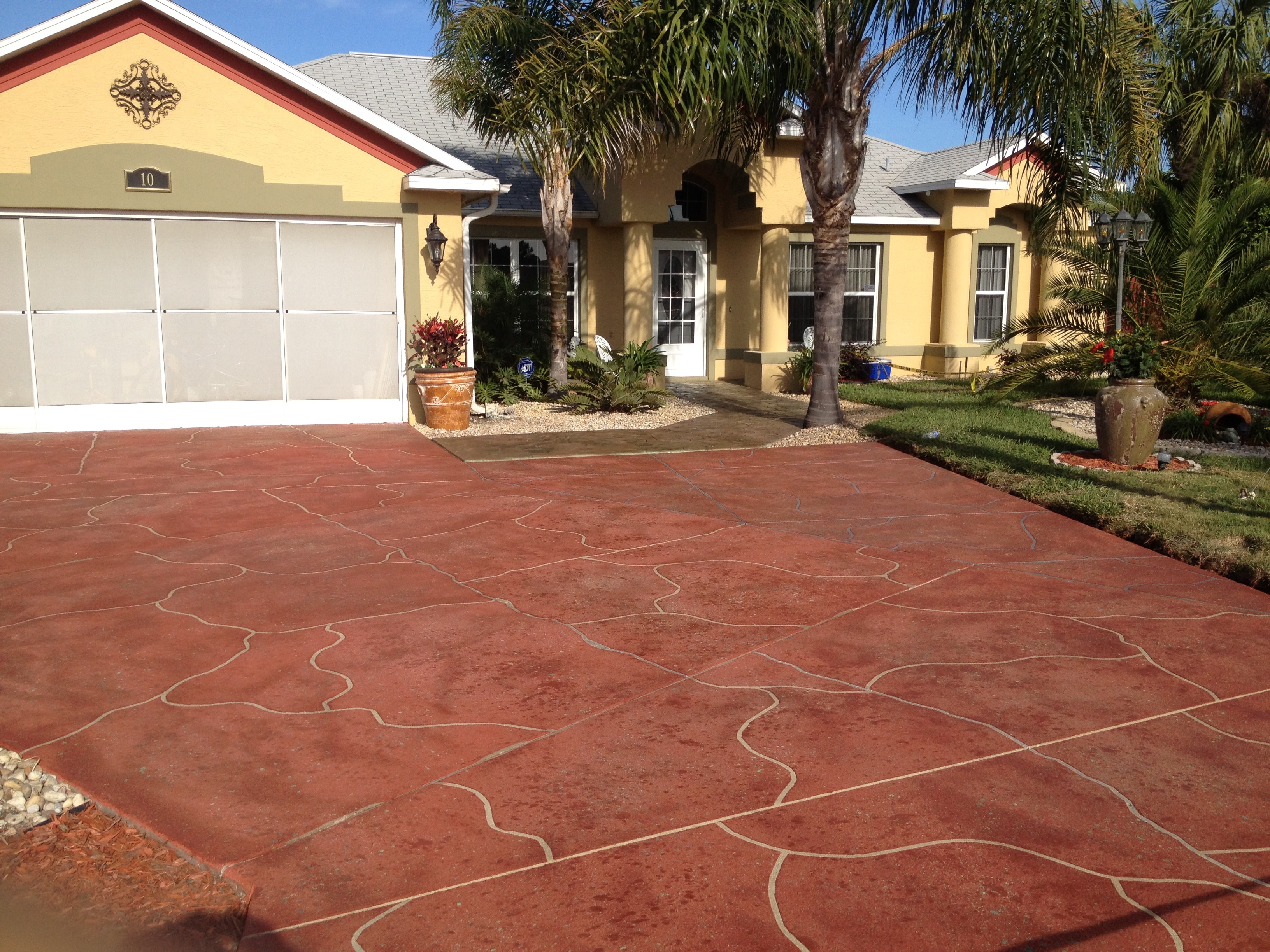 LunaCrete — yellow house with red driveway and palm trees