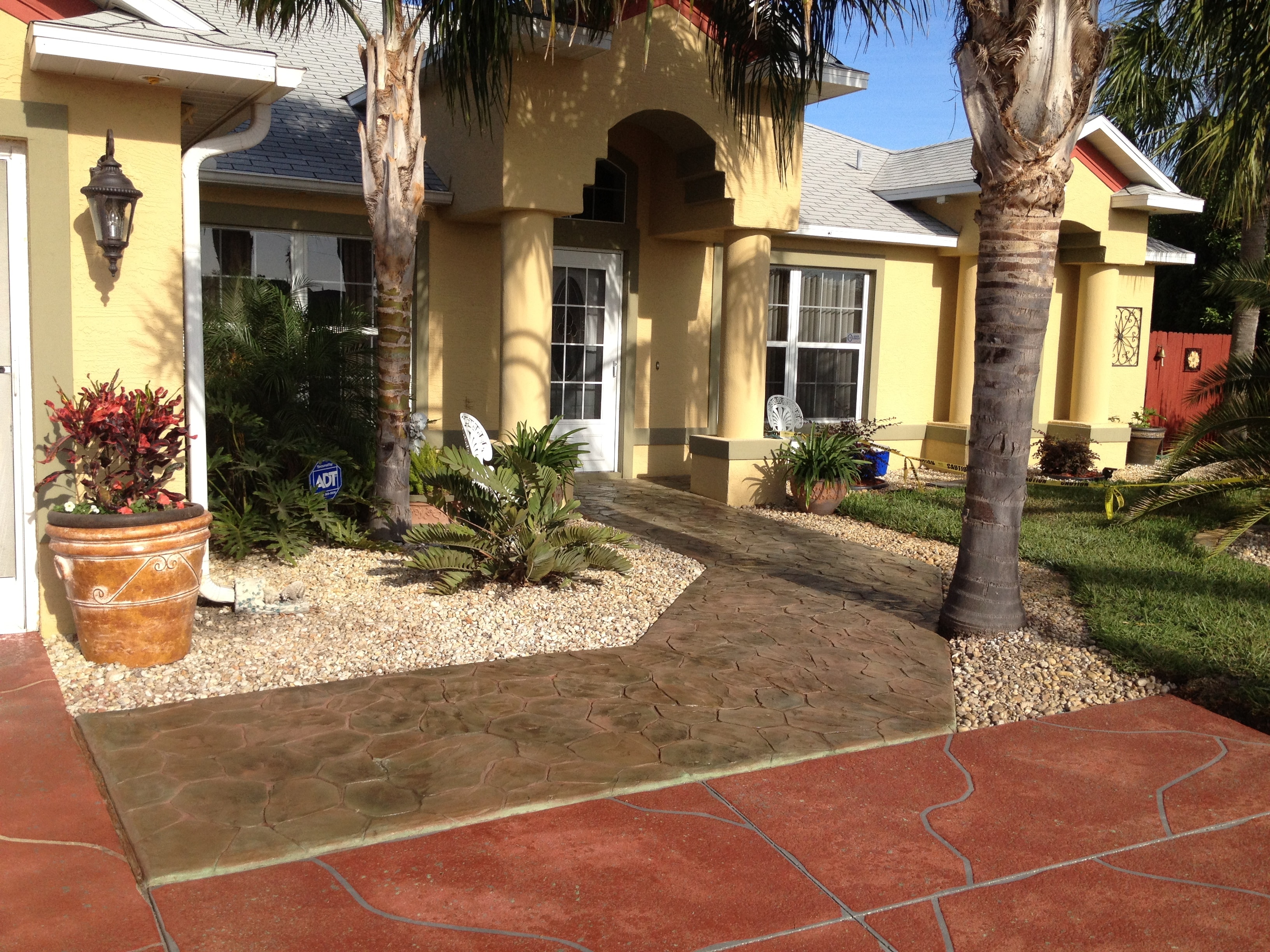 LunaCrete — yellow house with palm trees landscaping